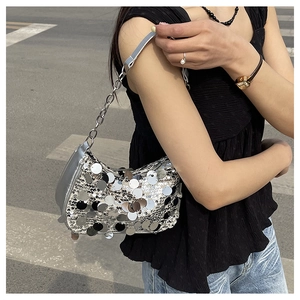 Vue détaillée du sac à bandoulière à paillettes argentées avec chaîne et forme de selle