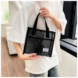 Detail of the durable black mesh fabric and sturdy woven handle on the portable tote bag