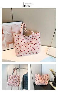 Dettaglio della borsa tote in velluto rosa con stampa a fragola e tasca frontale