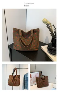 Dettaglio della borsa tote in velluto marrone con stampa floreale di fragole e manici