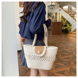 Detailed weave texture of this straw beach tote featuring a pearl clasp and leather flap