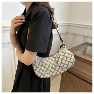 Détail d'un sac demi-lune en toile avec motifs floraux et finitions en cuir élégant