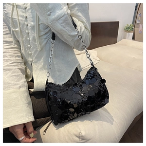 Détail d'un sac à bandoulière à paillettes noires avec chaîne argentée pour soirée