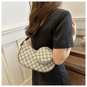 Détail du sac hobo en croissant avec motif trèfle, mini porte-monnaie et bandoulière