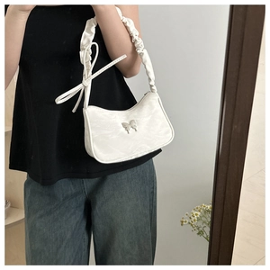 Detail of white marble textured shoulder bag with silver butterfly clasp and ruched strap