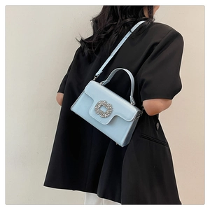 Détail du petit sac bleu clair avec boucle en cristal brillant et cuir synthétique lisse