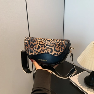 Detail of saddle bag with leopard print flap and wide striped shoulder strap accessory