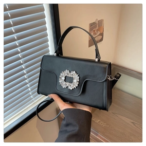 Détail du sac carré en cuir noir mat avec boucle en strass et bandoulière amovible