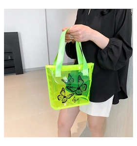 Detail of neon green transparent beach tote bag with black butterfly print and webbed handles