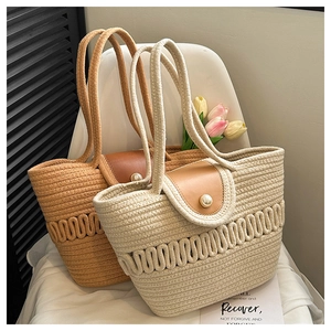 Detail of woven tote bags featuring leather flaps with elegant pearl buckles on a chair