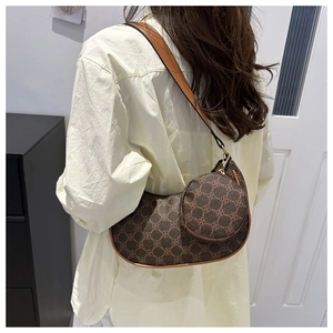 Vue détaillée du sac à bandoulière en croissant avec motif rétro et pochette ronde