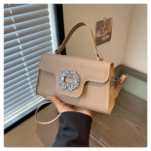 Détail du sac à main beige carré avec boucle en strass et bandoulière en cuir souple