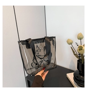 Detail of transparent grey PVC tote bag with elegant black butterfly prints and handles