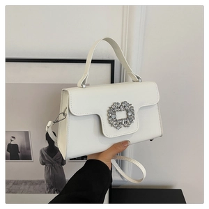 Détail du sac en similicuir blanc avec boucle ronde en strass et poignée élégante