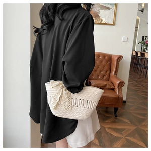 Détail du sac cabas tissé crème avec rayures ajourées et nœud en dentelle sur mannequin