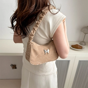 French retro beige baguette bag with silver butterfly and pleated strap on model