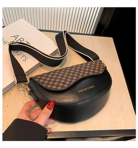 Detail of saddle bag with patterned flap, wide shoulder strap and gold-tone hardware