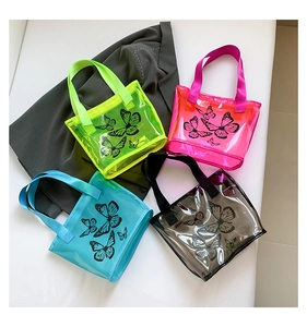 Close-up of transparent PVC beach bags with butterfly prints in four vibrant colors