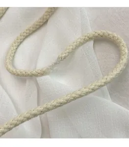 Macro detail of beige woven long shoulder strap with spiral texture on white fabric
