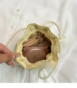 Interior view of straw bucket bag showing large capacity with drawstring closure detail