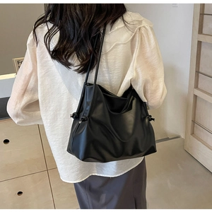 Vue détaillée du sac cabas en cuir noir avec d'élégants nœuds latéraux décoratifs