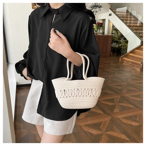 Détail de la texture tissée crème du sac à main avec motifs ondulés en 3D en café