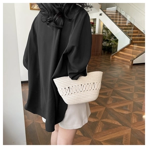 Détail du sac en paille tressée blanche avec motifs ajourés pour un style de vacances