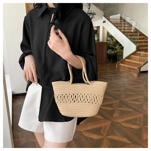 Détails d'un sac seau en paille tressé à la main avec motifs ondulés texturés