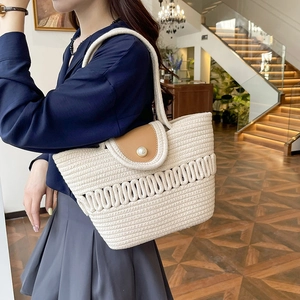 French woven straw beach bag with brown leather flap and large pearl closure