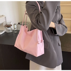 Grand sac cabas rose avec détails de nœuds et longue bandoulière sur le mannequin