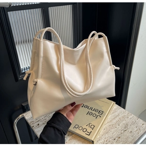 Détail du grand sac cabas en cuir crème avec nœuds latéraux et double bandoulière