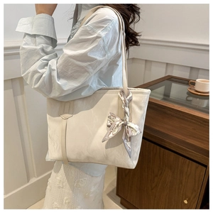 Détail d'un sac cabas blanc cassé avec texture plissée et foulard imprimé mode chic