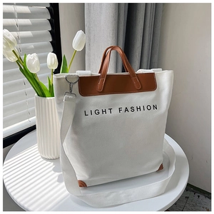 Detalle del bolso tote de lona blanca con asas de cuero marrón y estampado LIGHT FASHION