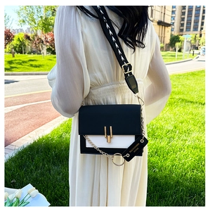Detail of black and white crossbody bag with gold chain and jacquard wide shoulder strap