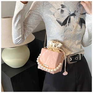Pink box bag with white faux pearl handle and gold chain strap shown on model