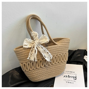 Gros plan détaillé du sac panier tressé avec nœud en dentelle crème et texture ondulée