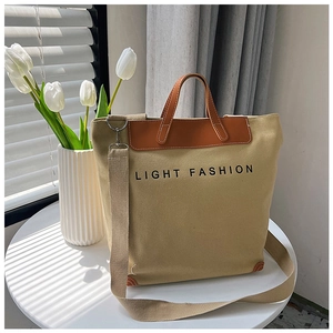 Detalle del bolso tote de lona con asas de cuero y estampado Light Fashion en mesa blanca