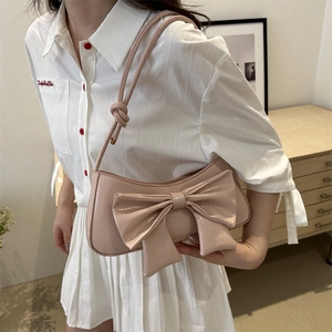 Pink glossy patent leather shoulder bag with oversized bow and slim crossbody strap