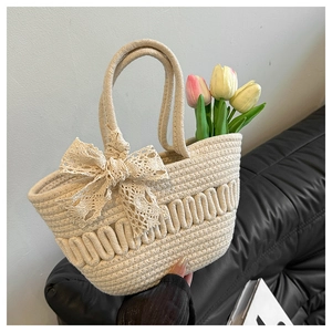 Détail du sac fourre-tout tissé blanc cassé avec un nœud en dentelle crème sur cuir
