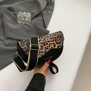 Detail of saddle bag with leopard print flap and wide canvas shoulder strap