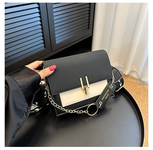 Detail of contrast crossbody bag with gold chain and printed wide fabric strap