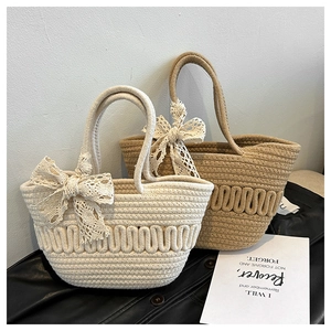 Détail de la texture d'un sac cabas tissé avec un nœud décoratif en dentelle