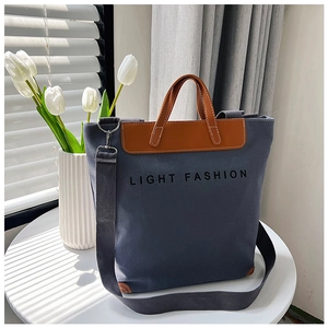 Detalle del bolso tote de lona gris con adornos de cuero y texto Light Fashion