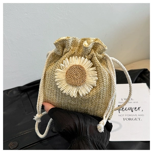 Detail of woven straw bucket bag with 3D sunflower accent and white drawstring closure