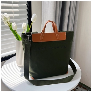 Detalle de bolso tote de lona verde oscuro con asas de cuero y texto LIGHT FASHION