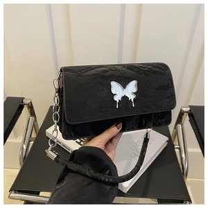 Close-up of black pleated shoulder bag with silver butterfly metal buckle detail