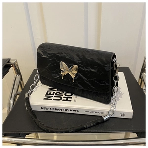 Close-up of black pleated leather shoulder bag with liquid silver butterfly hardware