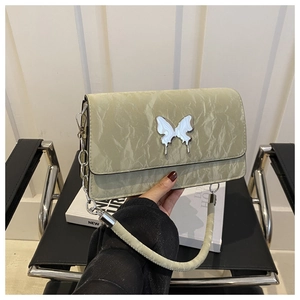 Detail of light green pleated shoulder bag with a silver butterfly metal buckle