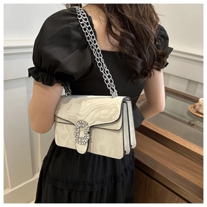 Side view of white marble pattern crossbody bag with large crystal buckle on a model