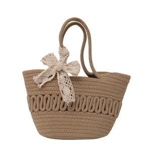 Sac cabas tressé marron avec nœud en dentelle beige sur fond blanc épuré